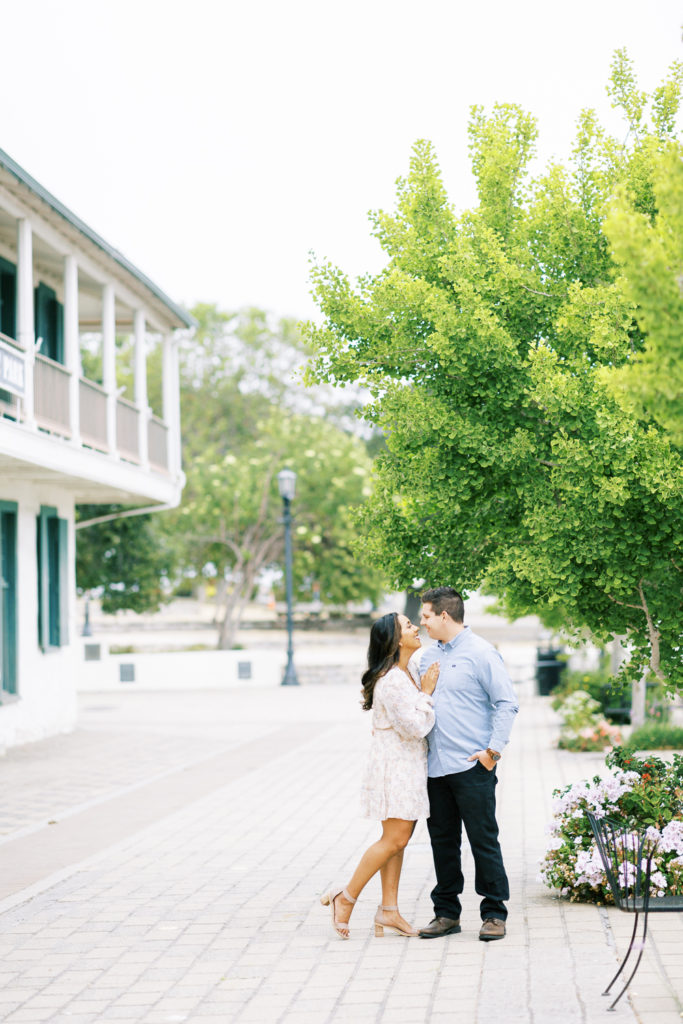 couple embracing in the middle of old town monterey for engagement photos in carmel