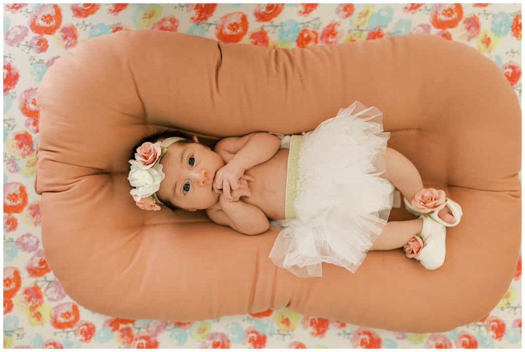 baby girl in tutu in pink floral crib