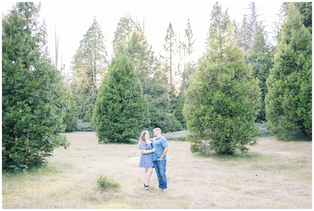 couple standing in mountain meadow smiling