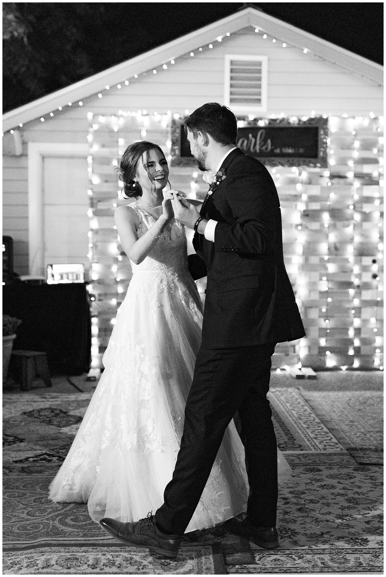 black and white image bride and groom dancing at reedley wedding at night smiling