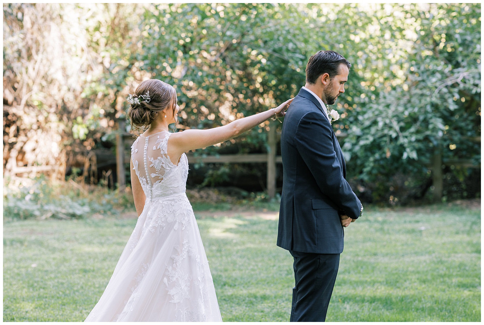 bride toughing grooms shoulder before groom turns around for first look