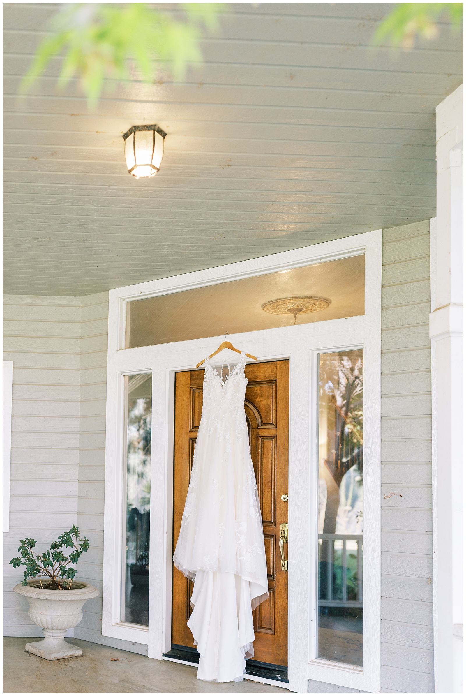 lace wedding dress hanging on door