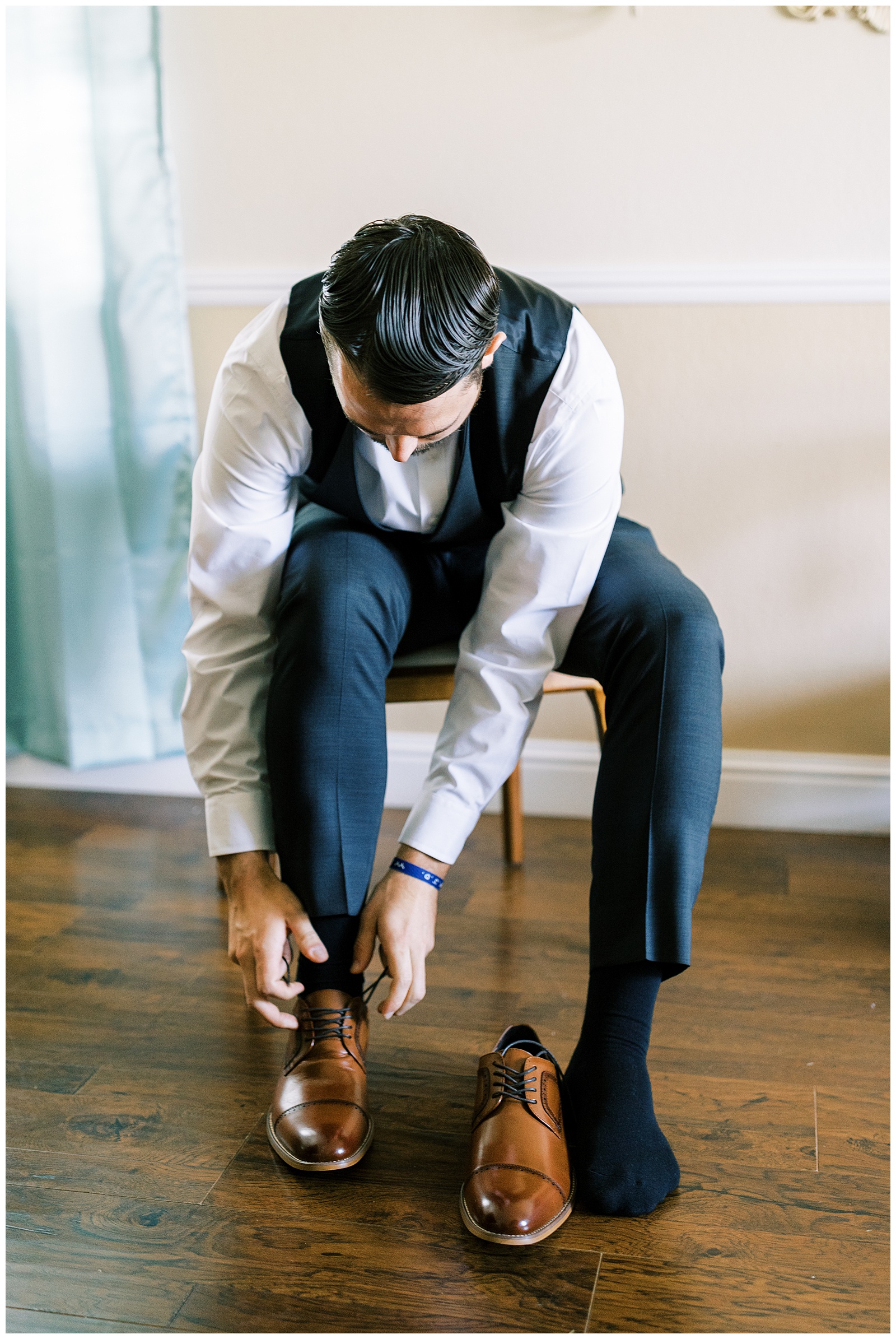 groom putting on brown dress shoes
