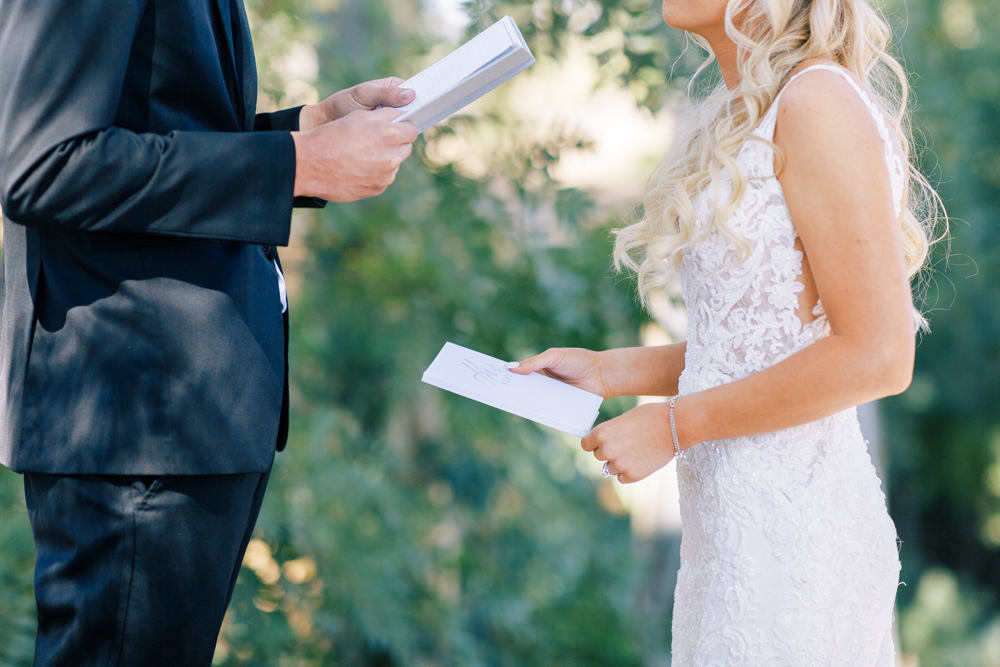 close up bride and groom holding vow books