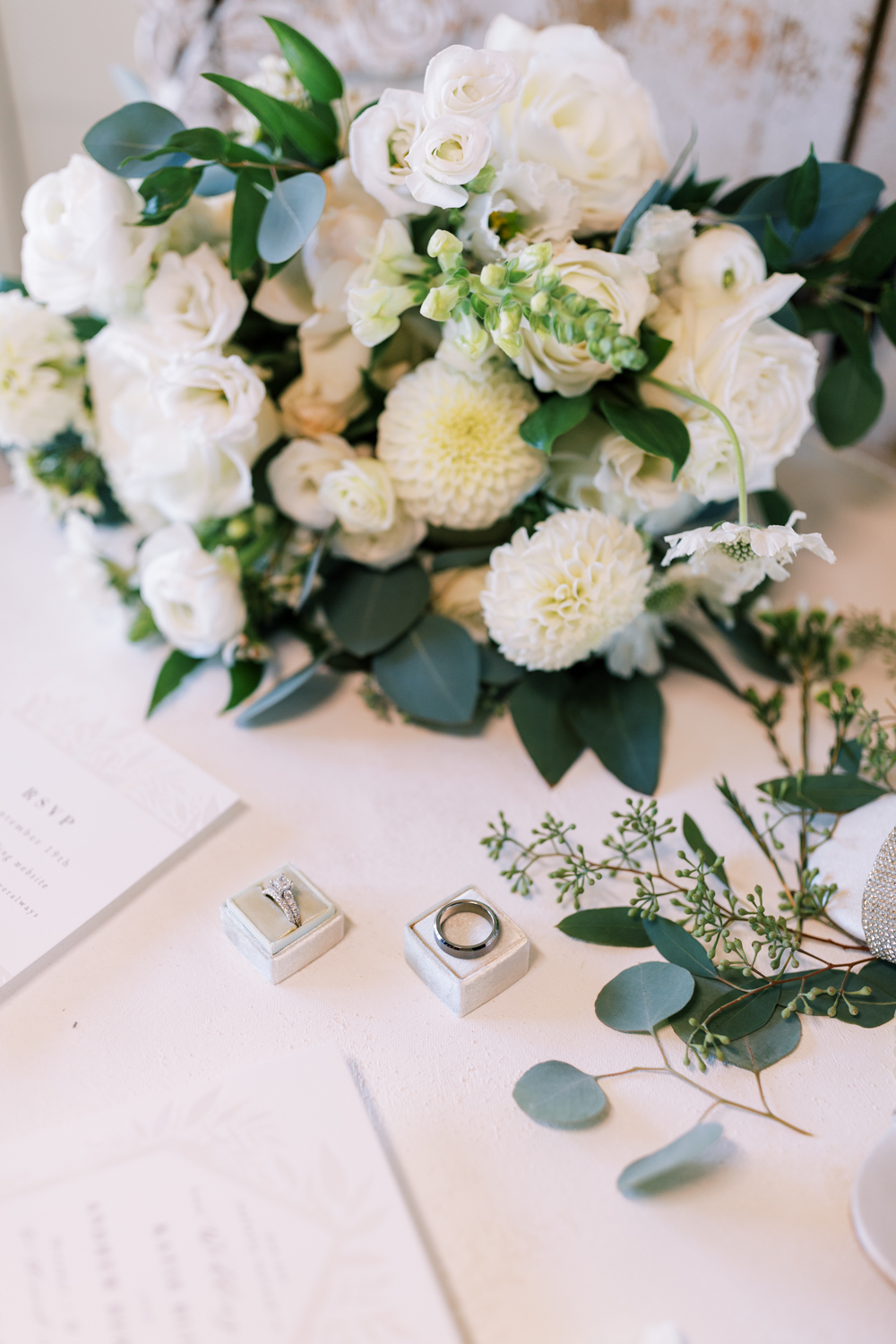 white and green wedding floral arrangement with classic wedding rings