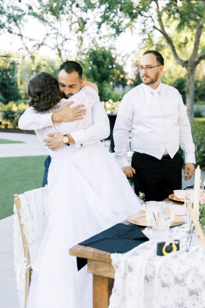 bride hugging guest during wedding reception