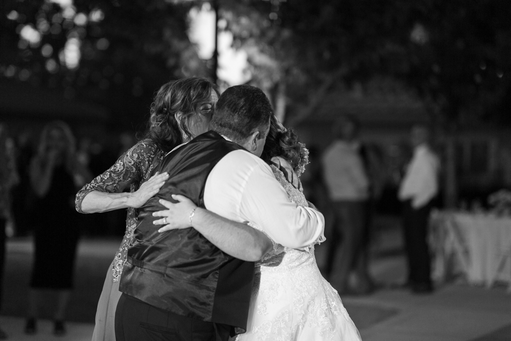 brides parents hugging during wedding dances