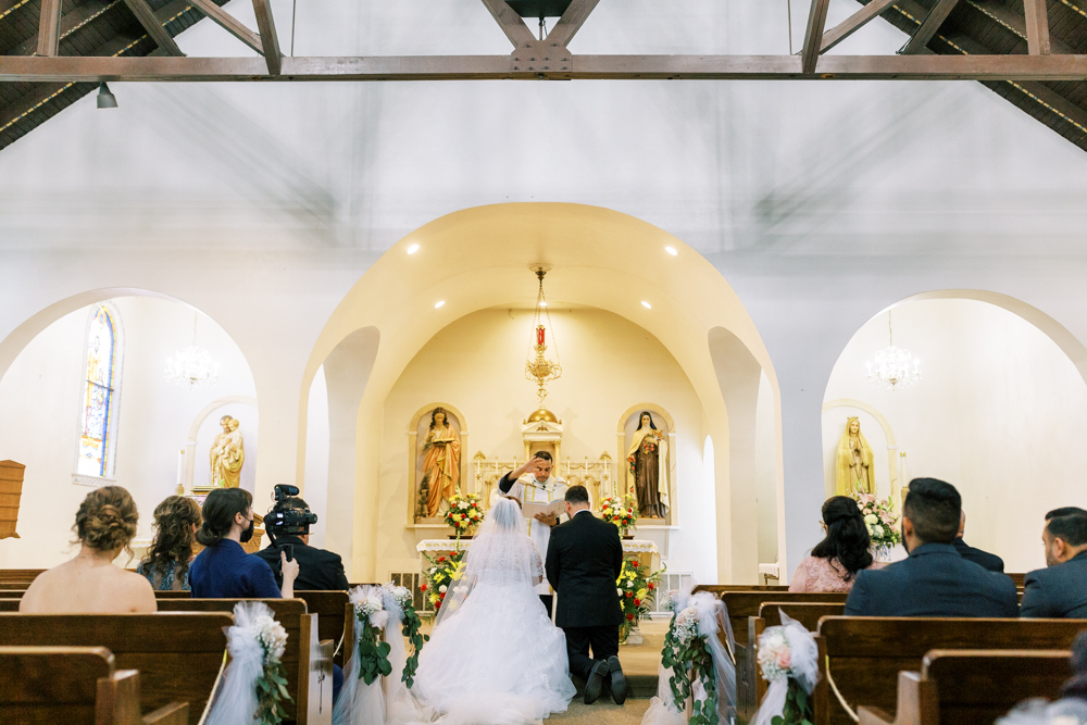 bride and groom kneeling during catholic wedding ceremony