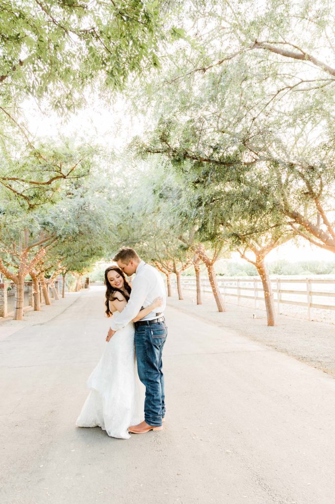 bride and groom along a tree lined driveway rustic wedding venues
