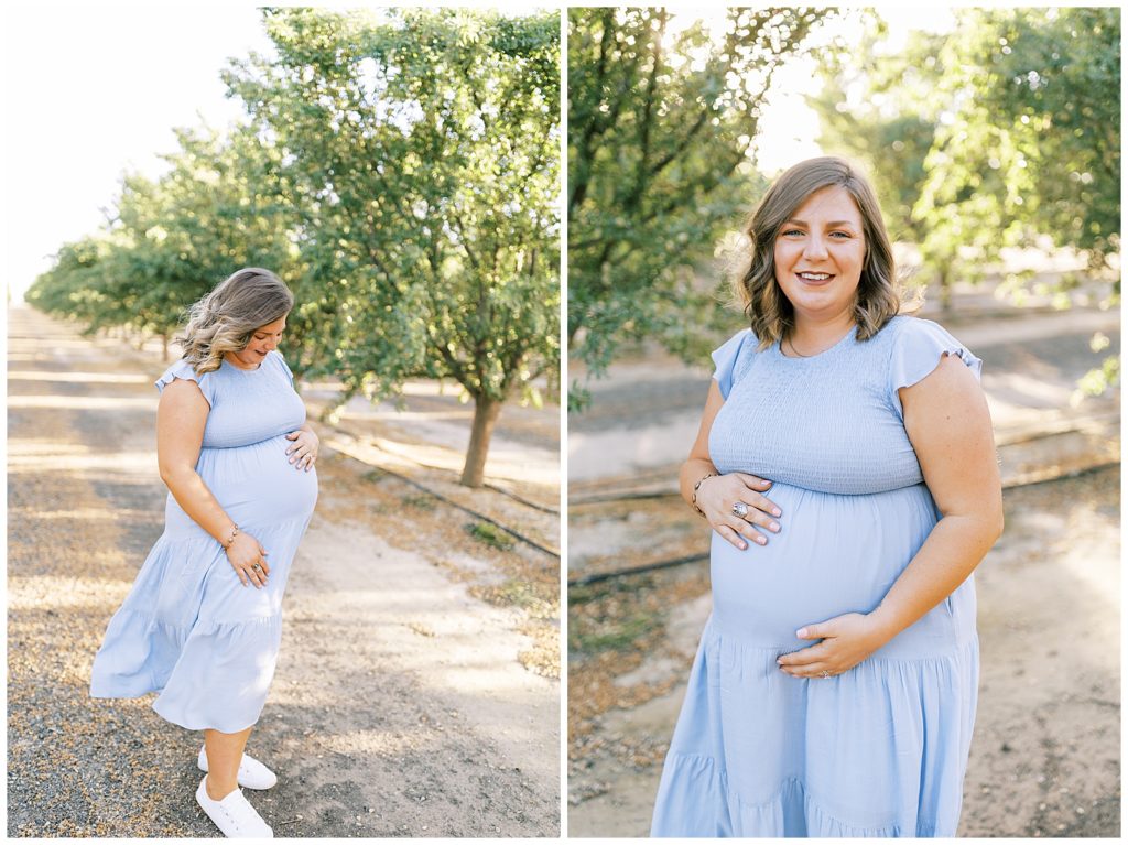 pregnant woman in blue dress smiling in glowing almond orchard
