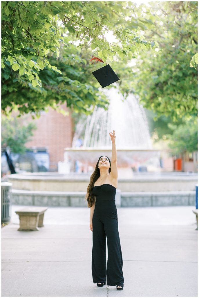 college graduate tossing graduation cap in the air
