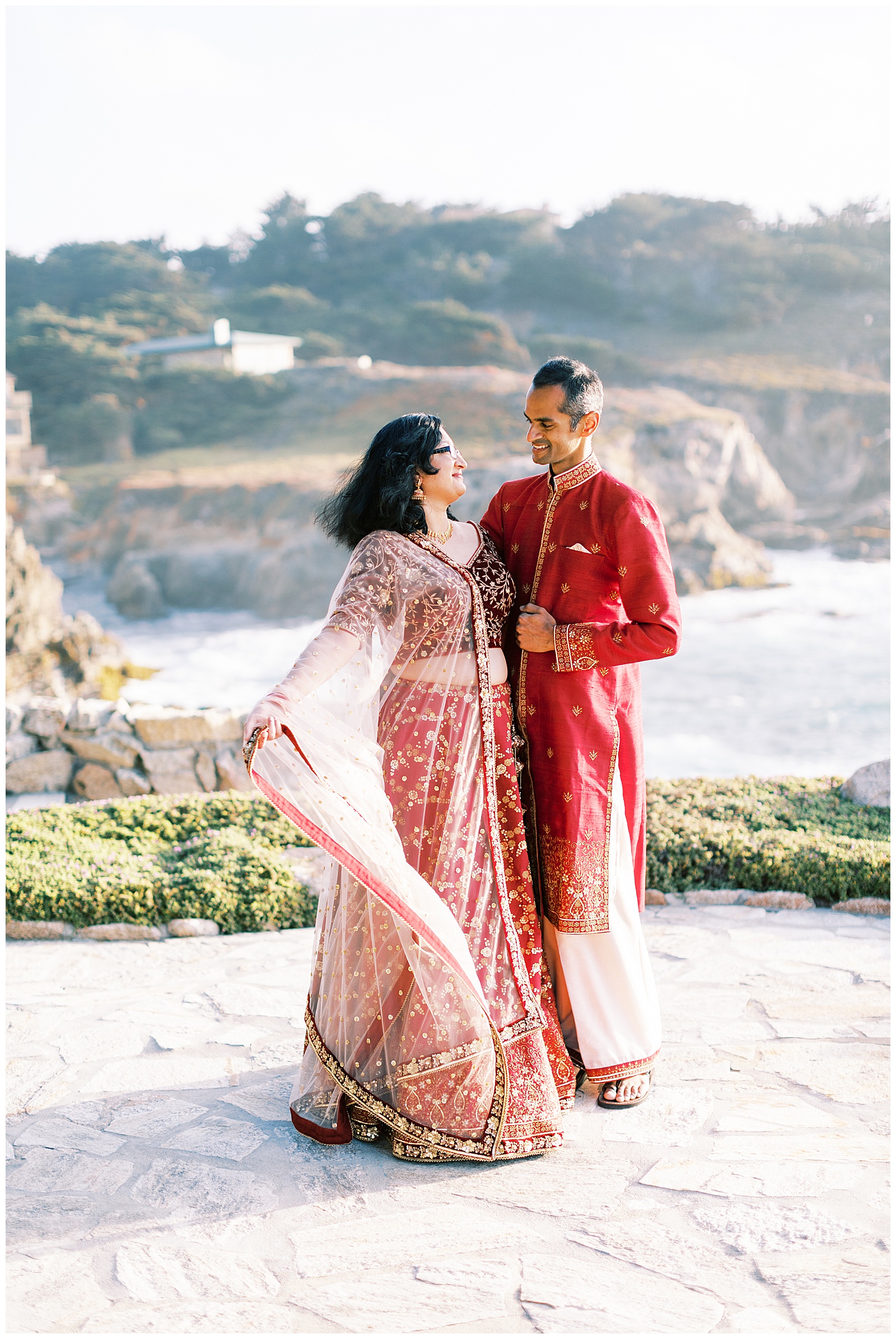 bride and groom on cliff by ocean in carmel-by-the-sea