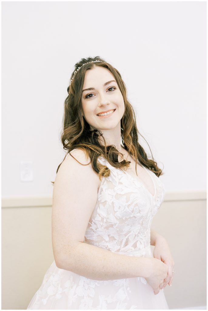 bride smiling in floral lace wedding dress