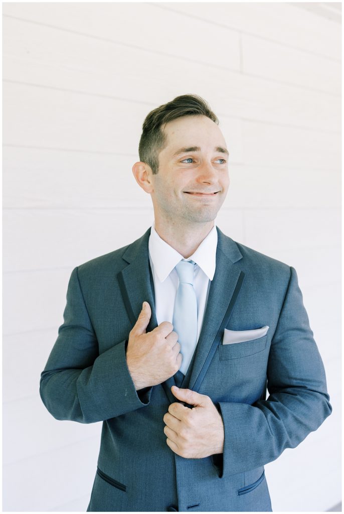 groom smiling in grey tuxedo