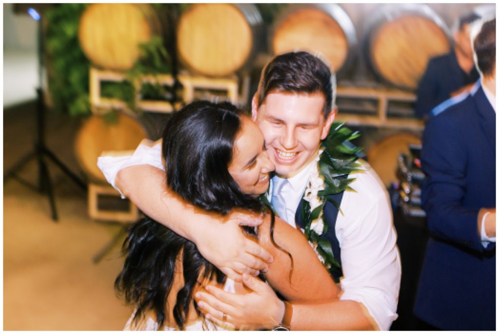 shutter drag image bride and groom hugging and smiling on wedding reception dance floor
