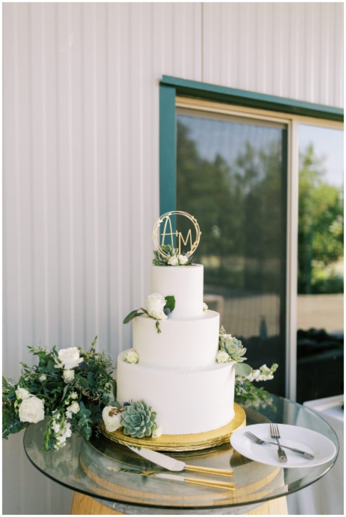 white simplistic wedding cake with gold cake topper
