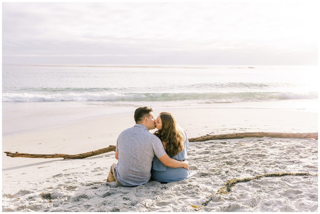 couple sitting on beach kissing